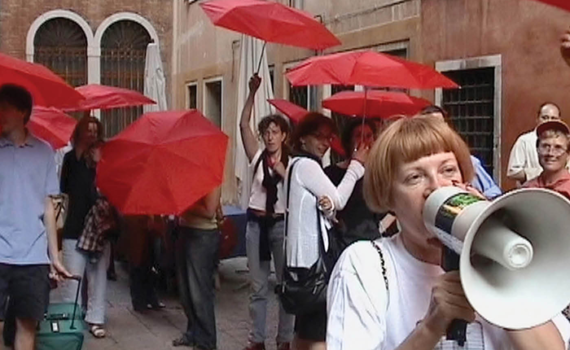 Cover of RHR Issue 149: May 2024, Troubling Terms and the Sex Trades. Red umbrella march, showing people with red umbrellas and person in foreground with megaphone and wearing shirt that says "sex worker."